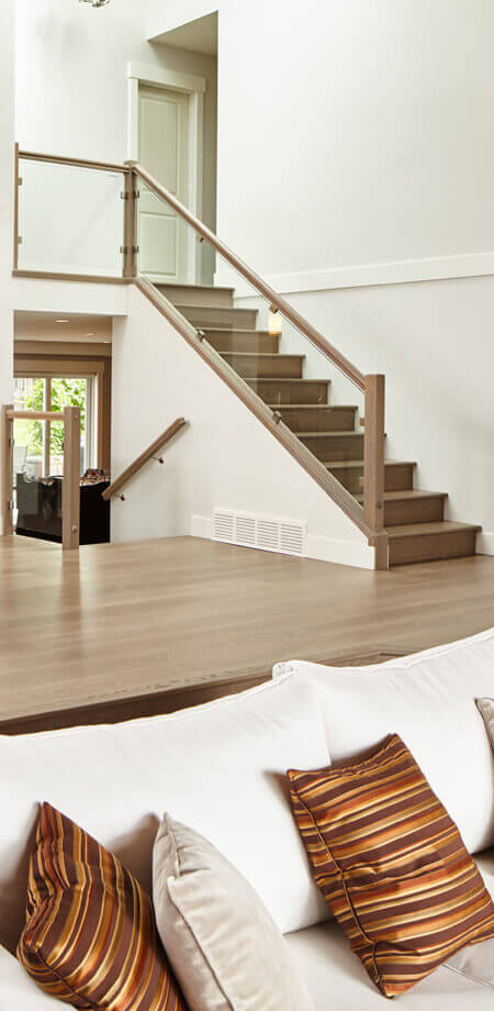modernized staircase with glass guard allows sight of seamless wood flooring to upper level