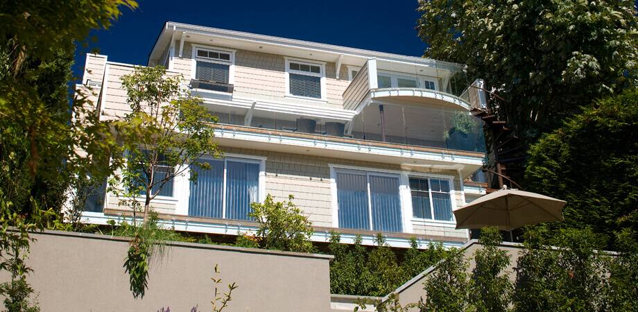 exterior renovation of north vancouver home with multiple glass railed decks for unobstructed views
