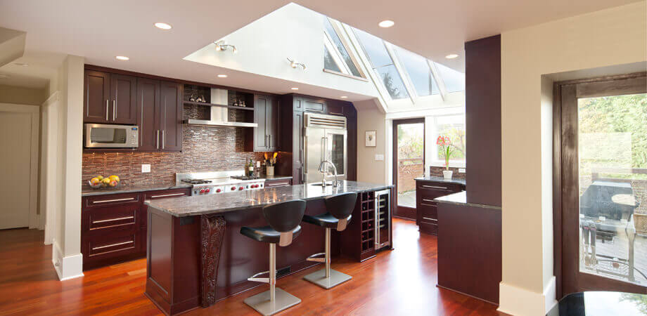 skylight floods dark cherry wood kitchen with natural light