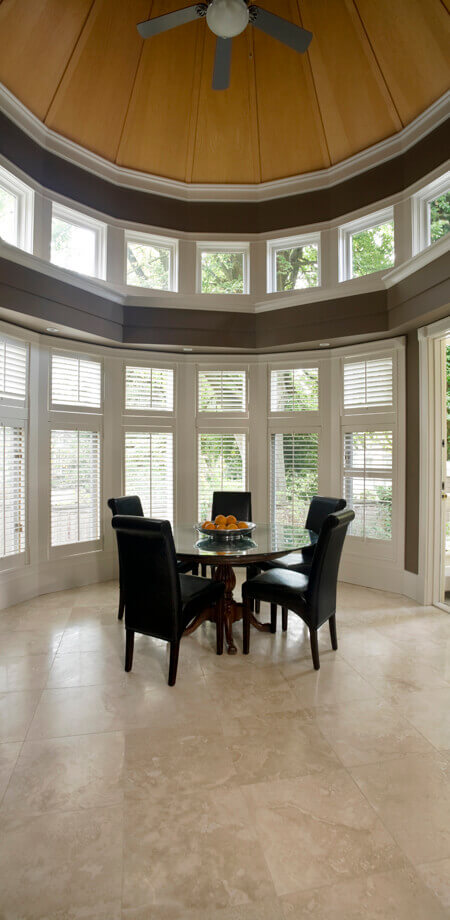Observatory style circular dining room with dome ceiling window surround and travertine tile floor