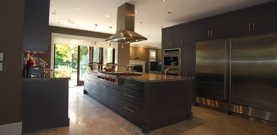 home kitchen designed with charcoal painted custom cabinetry and professional appliances