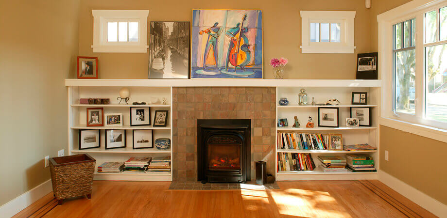 built in shelving surrounds both sides of modest fireplace